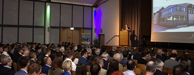 Das Foto zeigt einen vollbesetzen Saal und Regierungspräsident am Rednerpult anlässlich der Energiewende-Veranstaltung der Regierung von Niederbayern für Kommunen. 